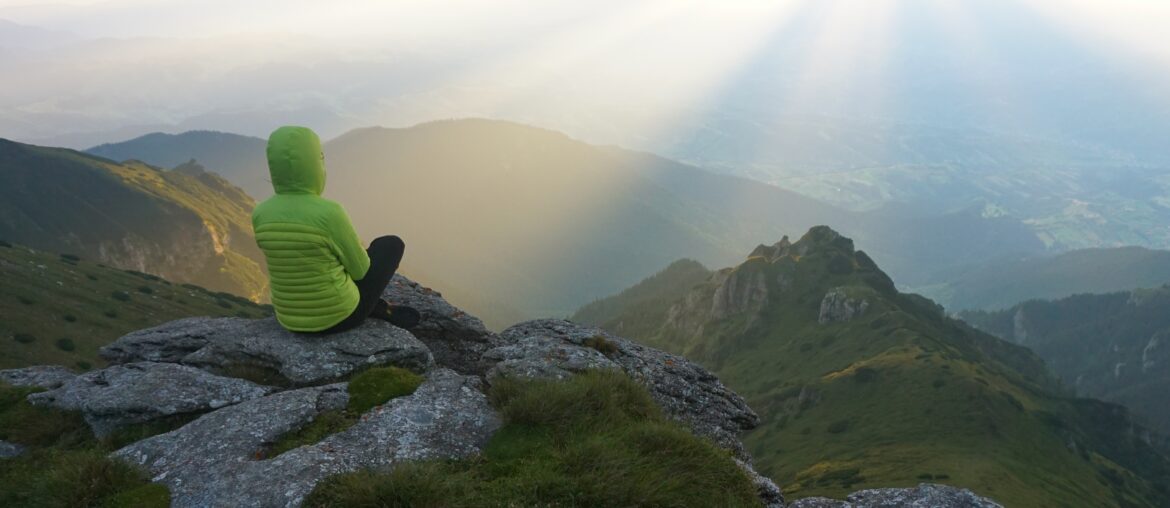 Mountain Life: A Life Above Dreams female-hiker-enjoying-view-from-summit-with-sun-s-rays-horizon
